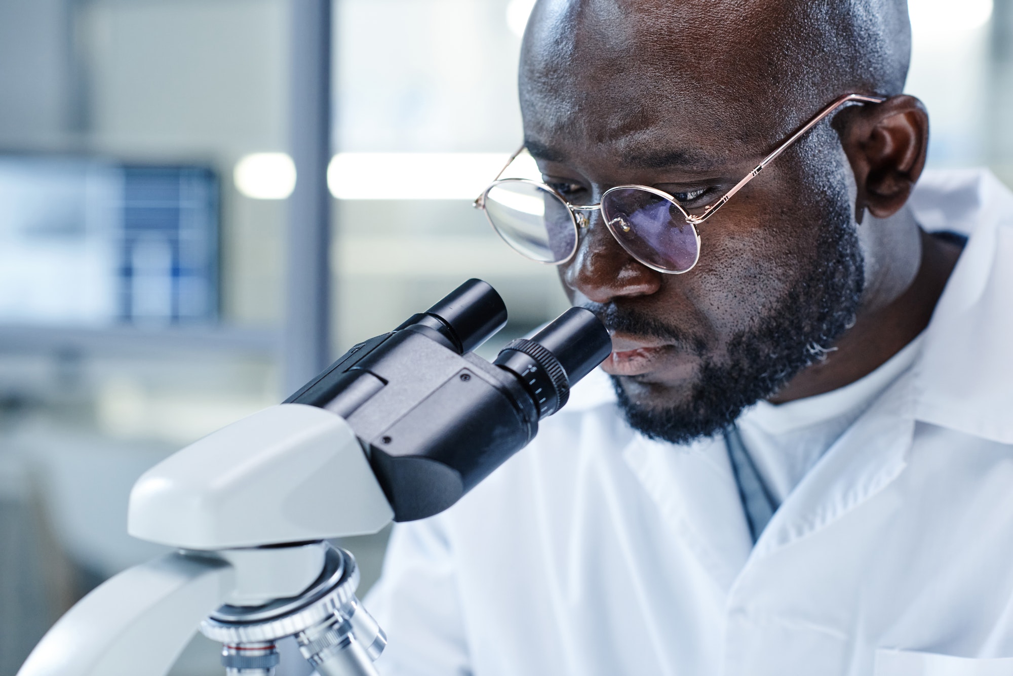 man working with microscope at the lab