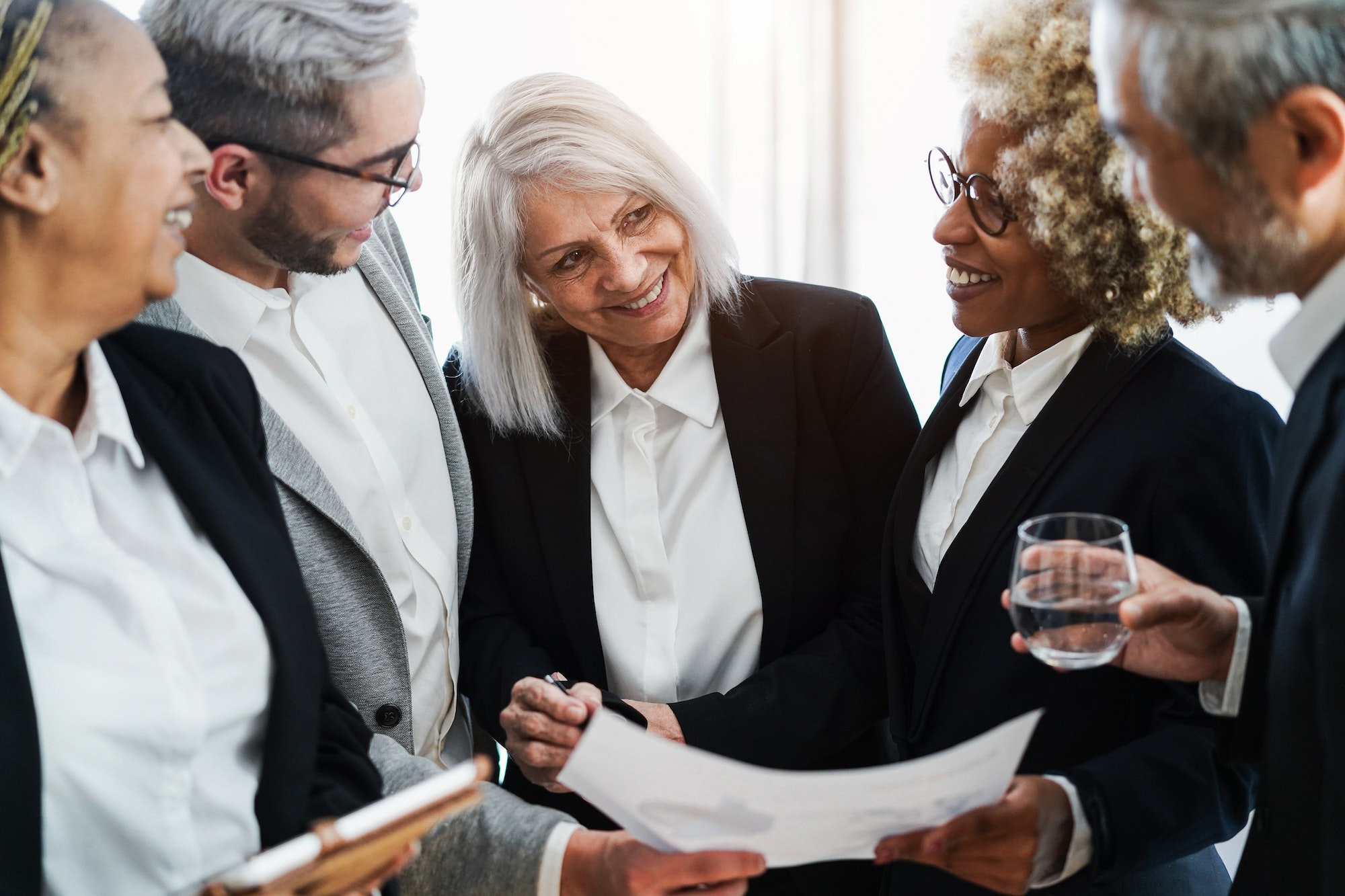 multiracial business people working inside bank office focus on senior woman face