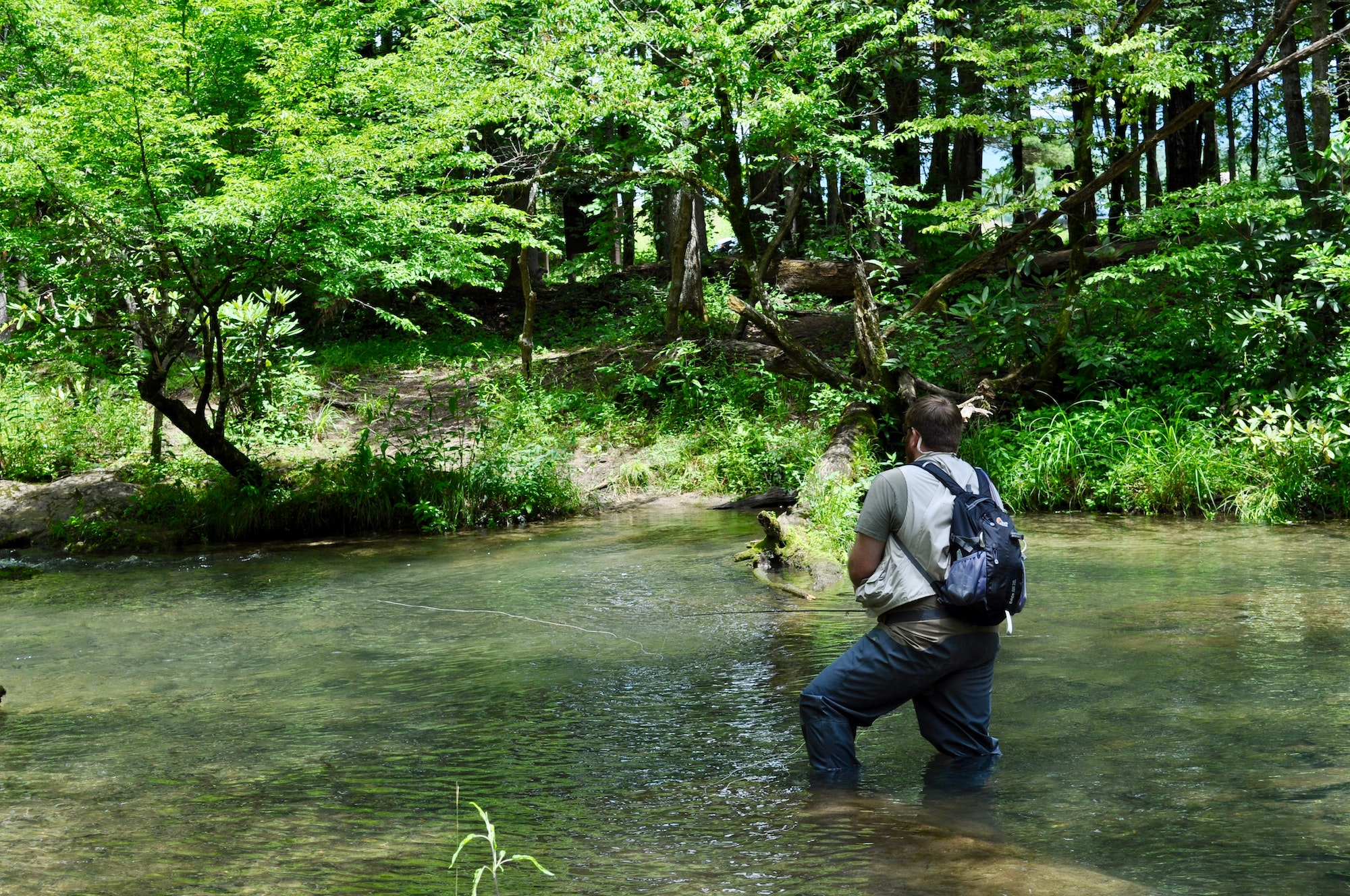 man fly fishing in a river